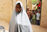 Hassana Mohammed, 13, seen outside her Dapchi home, scaled a fence to escape an alleged Boko Haram attack on her technical college which left more than 100 girls reported missing