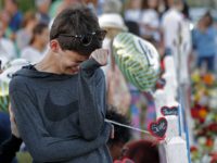 Daniel Bishop, 16, a student at Marjory Stoneman Douglas High School, cries at a makeshift memorial outside the school, in Parkland, Fla., Sunday, Feb. 18, 2018. Nikolas Cruz, a 19-year-old who had been expelled from the school, is being held without bail in the Broward County Jail, accused of 17 counts of first-degree murder. (AP Photo/Gerald Herbert)