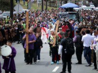 Thousands of people follows actors as they portray Jesus Christ and Roman centurions during a traditional Via Crucis, or Way of the Cross, procession on the Christian Good Friday holiday March 30, 2018 in Takoma Park, Maryland. The re-enactment of the crucifixion of Jesus drew several thousand area Catholics and marched its way through several Maryland neighborhoods in the suburbs of the nation's capital. (Photo by Chip Somodevilla/Getty Images)