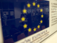 MELILLA, SPAIN - APRIL 02: African refugees are reflected in a sign of the European Union inside the Ferry Terminal of Melilla on the north African Spanish enclave of Melilla while boarding a cruise ship which is heading to Malage, the spanish mainland, on April 2, 2014, in Melilla, Spain. Melilla is a Spanish city and an exclave on the north coast of Africa sharing a border with Morocco. Almost one week ago Some 800 sub- Saharan people made several attempts to reach Spain and according to official sources, ten of them managed to enter Spanish territory. The migrants hide just west of the city centre and try to cross the 7-meter high fence to Melilla and into the European Union in hope of a better life. (Photo by Alexander Koerner/Getty Images)