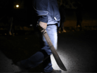 A hooded man carrying a machete patrols the streets in the village of 'Lo de Reyes', in the municipality of San Pedro Ayampuc, 20 km north of Guatemala City on March 2, 2017, to prevent attacks from gang members. The residents 'Lo de Reyes' were organized to defend themselves against criminals and stalking by members of the gangs 'Salvatrucha' and 'Barrio 18'. Guatemala, along with neighboring El Salvador and Honduras, suffers rampant violence, much of it linked to criminal gangs. Some 6,000 people a year are murdered in the country. / AFP PHOTO / Johan ORDONEZ (Photo credit should read JOHAN ORDONEZ/AFP/Getty Images)