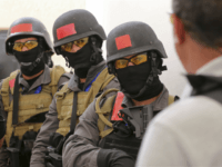 In this Sunday, March 18, 2018 photo, members of a Tunisian police commando unit listen to instructions during a drill at the Jordan Gendarmerie Training Academy, in al-Swaqa, about 44 miles (70 km) south of Amman, Jordan. The U.S.-funded center, which formally opens Thursday, will conduct counter-terrorism training for law enforcement agencies from a pool of 56 eligible partner countries. (AP Photo/Raad Adayleh)