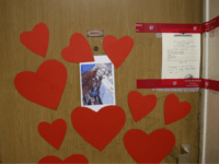 View of the apartment door of 85-year-old Mireille Knoll who was was slain last week, in Paris, France, Tuesday, March 27, 2018. Police seals, hearts and a photo of her are pasted on her entry way. Knoll had been stabbed several times and her apartment set on fire. Two suspects have been given preliminary charges of murder with anti-Semitic motives over the death of an elderly Jewish woman, a French judicial official said Tuesday. (AP Photo/Christophe Ena)