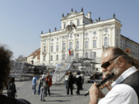 Street musicians play their instruments as tourist walk past the stage where US President Barack Obama will deliver his public speech on Sunday April 5, at the Hradcanske Square in Prague, Czech Republic on Friday, April 3, 2009. Obama will attend a summit between the United States and the 27-member European Union in Prague on Sunday. (AP Photo/Petr David Josek)