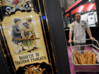 A man carries a cart full of baguettes as a sign reads 'French traditionnal baguette' during Europain 2014, a World Bakery, Patisserie and Catering exhibition held in Villepinte, north of Paris, on March 9, 2014. AFP PHOTO / PIERRE ANDRIEU (Photo credit should read PIERRE ANDRIEU/AFP/Getty Images)