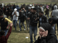 A Palestinian woman reacts from the fire shooting by Israeli troops during a demonstration near the Gaza Strip border with Israel, in eastern Gaza City, Friday, March 30, 2018. (AP Photo/Khalil Hamra)