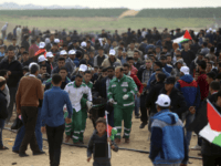 Palestinian medics carry a wounded man who was shot by Israeli troops during a demonstration near the Gaza Strip border with Israel, in eastern Gaza City, Friday, March 30, 2018. (AP Photo/ Khalil Hamra)