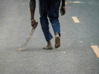 A supporter of National Super Alliance (NASA) holding a machete reacts towards police officers during a protest against Kenya's second poll in Kisumu, on October 27, 2017. Kenya's election chief said on October 27 plans to restage a presidential vote on October 28 in areas hit by polling-day protests would be postponed 'to a further date' because of fresh violence. / AFP PHOTO / YASUYOSHI CHIBA (Photo credit should read YASUYOSHI CHIBA/AFP/Getty Images)