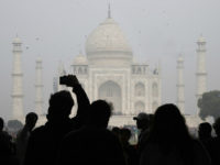 TOPSHOT - Visitors take a photo in front of the Taj Mahal in Agra on January 3, 2018. India is to restrict the number of daily visitors to the Taj Mahal in an effort to preserve the iconic 17th-century monument to love, its biggest tourist draw. Millions of mostly Indian tourists visit the Taj Mahal every year and their numbers are increasing steadily as domestic travel becomes more accessible. / AFP PHOTO / DOMINIQUE FAGET (Photo credit should read DOMINIQUE FAGET/AFP/Getty Images)