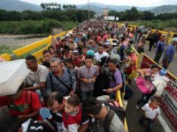 Venezuelan citizens cross the Simon Bolivar international bridge from San Antonio del Tachira in Venezuela to Norte de Santander province of Colombia on February 10, 2018. Oil-rich and once one of the wealthiest countries in Latin America, Venezuela now faces economic collapse and widespread popular protest. / AFP PHOTO / GEORGE CASTELLANOS (Photo credit should read GEORGE CASTELLANOS/AFP/Getty Images)