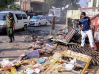 Sri Lankan police commandos patrol next to debris of from a damaged shop in the central district of Kandy on March 6, 2018, after a state of emergency was declared