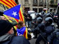 Protesters scuffle with riot police blocking the road leading to the central government offices in Barcelona at a demonstration against the arrest of ex-Catalan president Carles Puigdemont