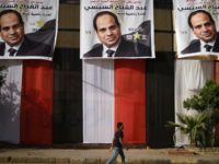An Egyptian youth walks past a polling station in the capital Cairo's western Giza district on March 25, 2018, ahead of a vote that saw President Abdel Fattah al-Sisi reelected to a second term in office