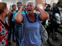 A relative of a prisoner cries in front of a police station in Valencia after a deadly fire that killed 68 people