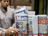 A man takes a copy of newspaper at a grocery shop in Shah Alam, Malaysia, Monday, March 26, 2018. Malaysia's government on Monday proposed new legislation to outlaw fake news with a 10-year jail term for offenders, in a move slammed by critics as a draconian bid to crack down on dissent ahead of a general election. Prime Minister Najib Razak has been dogged by a multibillion-dollar corruption scandal involving an indebted state fund, and rights activists fear the new law could be used to criminalize reports on government misconduct and critical opinions. (AP Photo/Sadiq Asyraf)