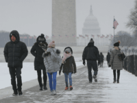 People are seen walking alongside the reflecting pool on the National Mall in Washington, Thursday, Jan. 4, 2018. Residents across a huge swath of the U.S. have awakened to the beginnings of a massive winter storm expected to deliver snow, ice and high winds followed by possible record-breaking cold as it moves up the Eastern Seaboard from the Carolinas to Maine. (AP Photo/Pablo Martinez Monsivais)