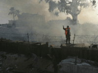 Palestinians Firefighters hose down a fire in Egypt, as they work over the separation fence between Egypt and Rafah, in the southern Gaza Strip, Thursday, Feb. 26, 2009. Hamas security officials say Israeli aircraft have attacked smuggling tunnels in the Gaza Strip. (AP Photo/Eyad Baba)