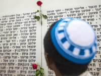 An Israeli man prays in front of a commemorative plaque celebrating fallen soldiers and decorated with roses at the Armored Corps memorial, following a ceremony to mark Remembrance Day (or Memorial Day) on May 5, 2014 at Latrun Junction, near Jerusalem. Israel is marking Remembrance Day to commemorate the fallen Israeli soldiers killed since 1860 and civilians killed in hostile actions since 1948, just before the celebrations of the 66th anniversary of its creation according to the Jewish calendar. AFP PHOTO / JACK GUEZ (Photo credit should read JACK GUEZ/AFP/Getty Images)