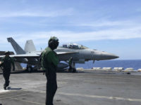 Crewmen of the U.S. aircraft carrier Theodore Roosevelt prepare their aircraft Tuesday, April 10,2018 in international waters off South China Sea. The aircraft carrier Theodore Roosevelt (CVN-71) is sailing through the disputed South China Sea in the latest display of America's military might after China built a string of islands with military facilities in the strategic sea it claims almost in its entirety. (AP Photo/Jim Gomez)