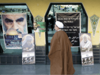 An Iranian clergyman passes anti-Israeli posters, during activities marking the 10th anniversary of the assassination of the late Palestinian Islamic Jihad leader, Fathi Shaqaqi in Tehran, 30 October 2005. Iran's hardline President Mahmoud Ahmadinejad insisted today that his controversial call for Israel to be 'wiped off the map' was nothing new, stressing that he was merely quoting Iran's late revolutionary leader Ayatollah Ruhollah Khomeini. AFP PHOTO/BEHROUZ MEHRI (Photo credit should read BEHROUZ MEHRI/AFP/Getty Images)