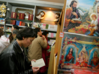 Chinese Catholics shop for bibles after midnight Christmas mass at a government approved Catholic church in Beijing, 25 December 2007. China's official Catholic church has installed a new Vatican-approved bishop, the third in a month, state media and a Rome-based religious news agency reported on 22 December as up to an estimated 10 million 'underground' Chinese Catholics pledge allegiance to the pope, worship in unofficial churches and are often subject to police and government harassment. AFP PHOTO/TEH ENG KOON (Photo credit should read TEH ENG KOON/AFP/Getty Images)