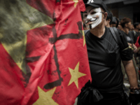 A man wears a mask of the Anonymous hacker group as he and other people take part in a protest for the cause of late Chinese dissident Li Wangyang in Hong Kong on June 10, 2012. Li, 62, who spent 22 years in jail for his role in the Tiananmen democracy protests died in allegedly suspicious circumstances in his hospital ward in central China's Hunan province on June 6 by his sister and brother-in-law.