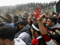 Palestinian protesters evacuate a wounded youth during clashes with Israeli troops along the Gaza Strip border with Israel, east of Khan Younis, Gaza Strip, Friday, March 30, 2018. (AP Photo/Adel Hana)