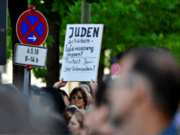 A protester holds a placard during the 'Berlin wears kippa' event, with more than 2,000 Jews and non-Jews wearing the traditional skullcap to show solidarity with Jews on April 25, 2018 in Berlin after Germany has been rocked by a series of anti-Semitic incidents. - Germans stage shows of solidarity with Jews after a spate of shocking anti-Semitic assaults, raising pointed questions about Berlin's ability to protect its burgeoning Jewish community seven decades after the Holocaust. (Photo by Tobias SCHWARZ / AFP) (Photo credit should read TOBIAS SCHWARZ/AFP/Getty Images)