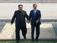 In this image taken from video provided by Korea Broadcasting System Friday, April 27, 2018, North Korean leader Kim Jong Un, left, crosses the border into South Korea, along with South Korean President Moon Jae-in for their historic face-to-face talks, in Panmunjom. Their discussions will be expected to focus on whether the North can be persuaded to give up its nuclear bombs.(Korea Broadcasting System via AP)