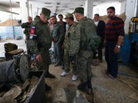 Russian military police officers check weapons left behind by members of the Army of Islam group in a factory produced weapons, in the town of Douma, the site of a suspected chemical weapons attack, near Damascus, Syria, Monday, April 16, 2018. Faisal Mekdad, Syria's deputy foreign minister, said on Monday that his country is 