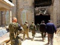 Russian forces patrol damaged buildings in Douma, Syria on the outskirts of Damascus on April 16, 2018 during an organised media tour after the Syrian army declared that all anti-regime forces have left Eastern Ghouta, following a blistering two month offensive on the rebel enclave. The announcement, which represents a key strategic victory for President Bashar al-Assad, came just hours after US-led strikes pounded Syrian government targets in response to a suspected chemical attack on the enclave's main town of Douma. / AFP PHOTO / LOUAI BESHARA (Photo credit should read LOUAI BESHARA/AFP/Getty Images)