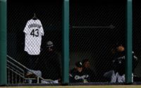 The jersey of Danny Farquhar of the Chicago White Sox, who is fighting for his life after emergency surgery to reduce swelling from a brain hemorrhage, hangs on the bullpen fence