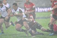 Sunwolves' Koo Ji-woo is tackled by Crusaders' Ethan Blackadder as a massive hailstorm rages in Christchurch