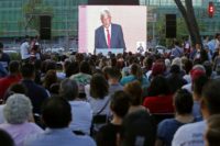 People watch a public television screen showing Mexico's presidential candidate for the MORENA party, Andres Manuel Lopez Obrador (C) during the first presidental debate