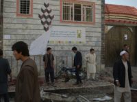 Residents inspect the site of a suicide bombing outside the voter registration centre