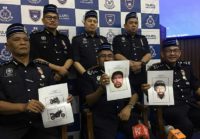 Malaysia's police chief Mohamad Fuzi Harun (C) with other police officials holding computer-generated images of the suspects