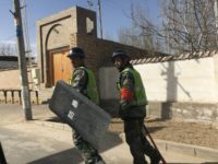 Police patrol a village in Hotan prefecture, in China's western Xinjiang region, where surveillance affects every aspect of daily life