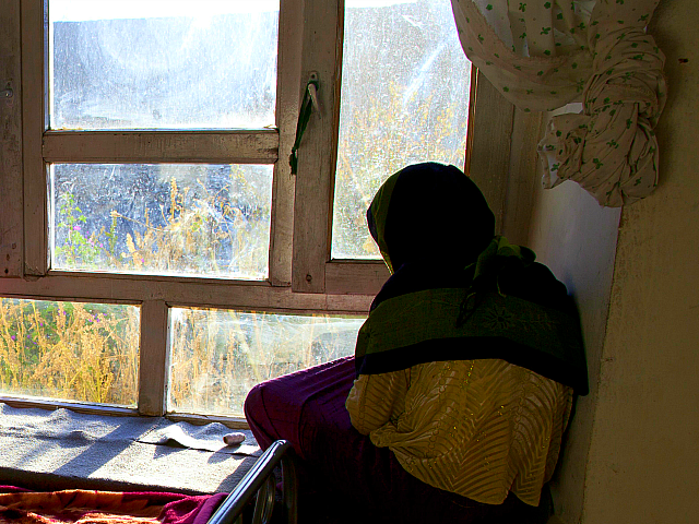BAMIYAN, AFGHANISTAN - OCTOBER 8: Rahima (L), 18, looks out the window of her room with another battered woman at a women's shelter October 8, 2010 in Bamiyan, Afghanistan. Rahima, from Maydan Wardak, was a child bride, forced to marry at age 11. Until women's shelters were started, something that …