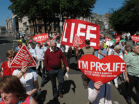 Anti-abortion protesters holding placards walk through Ireland's capital, Dublin, in an anti-abortion protest Saturday, July 6, 2013. More than 35,000 activists marched to the parliament building to oppose Irish government plans to enact a bill legalizing terminations for women in life-threatening pregnancies. The Protection of Life During Pregnancy Bill is expected to be passed into law next week. (AP Photo/Shawn Pogatchnik)