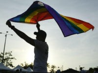man-waving-gay-pride-flag-17-ap A man holds up a rainbow flag at the end of the annual Gay Pride parade in Panama City, Saturday, July, 1, 2017. . (AP Photo/Arnulfo Franco)