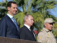 Russian President Vladimir Putin, his Syrian counterpart Bashar al-Assad and Russian Defence Minister Sergei Shoigu inspect a military parade during a visit to a Russian air base in Hmeimim Russian President Vladimir Putin, his Syrian counterpart Bashar al-Assad and Russian Defence Minister Sergei Shoigu inspect a military parade during a visit to a Russian air base in Hmeimim