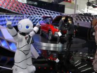 In this April 26, 2018, photo, a robot entertains visitors at the booth of a Chinese automaker during the China Auto 2018 show in Beijing, China. Under President Xi Jinping, a program known as "Made in China 2025" aims to make China a tech superpower by advancing development of industries that in addition to semiconductors includes artificial intelligence, pharmaceuticals and electric vehicles. (AP Photo/Ng Han Guan)