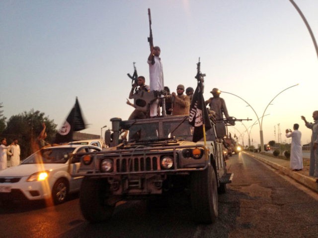 In this June 23, 2014 file photo, fighters from the Islamic State group parade in a commandeered Iraqi security forces armored vehicle on the main road in Mosul, Iraq. In a statement Thursday, May 10, 2018, coalition spokesman Army Col. Ryan Dillon said that U.S.-backed Syrian forces have captured five senior Islamic State group leaders. Dillon called the arrest a "significant blow to Daesh," using the Arabic acronym for the extremist group. (AP Photo, File)