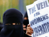 burqa ban BLACKBURN, UNITED KINGDOM - OCTOBER 14: A Muslim woman wearing a niqab veil protests outside Bangor Street Community centre where Leader of the House of Commons Jack Straw is holding one of his weekend surgery appointments where he faced a protest by around 50 Muslim protesters on October 14, 2006, …