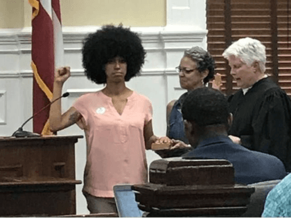 Georgia Commissioner Takes Oath of Office with Black Power Fist in Air and Hand on Malcolm X Bio