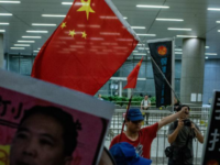 Hong Kong train station demonstration A Pro-Beijing protester (back centre) holds a Chinese flag during the anti-rail link rally outside the Legco complex in Hong Kong on June 14.