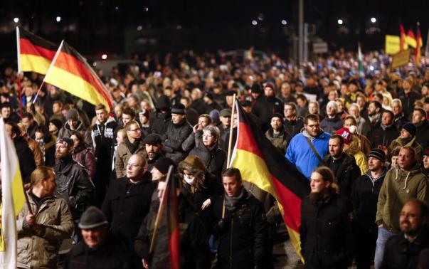 Participants hold German national flags during a demonstration called by anti-immigration group PEGIDA in Dresden