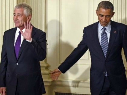 President Barack Obama reaches over to touch Defense Secretary Chuck Hagel following an announcement of Hagel's resignation.
