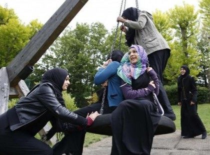 Yasmin pushes Hana on a swing after finishing a GCSE exam near their school in Hackney, east London