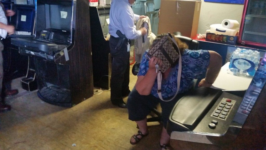 Woman covers her face during gambling raid. Breitbart Texas photo by Ildefonso Ortiz.